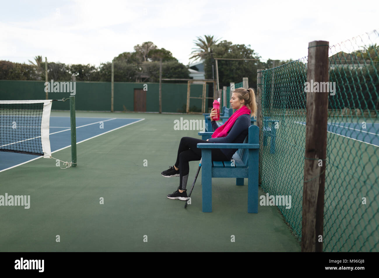 Woman drinking water in tennis court Stock Photo Alamy