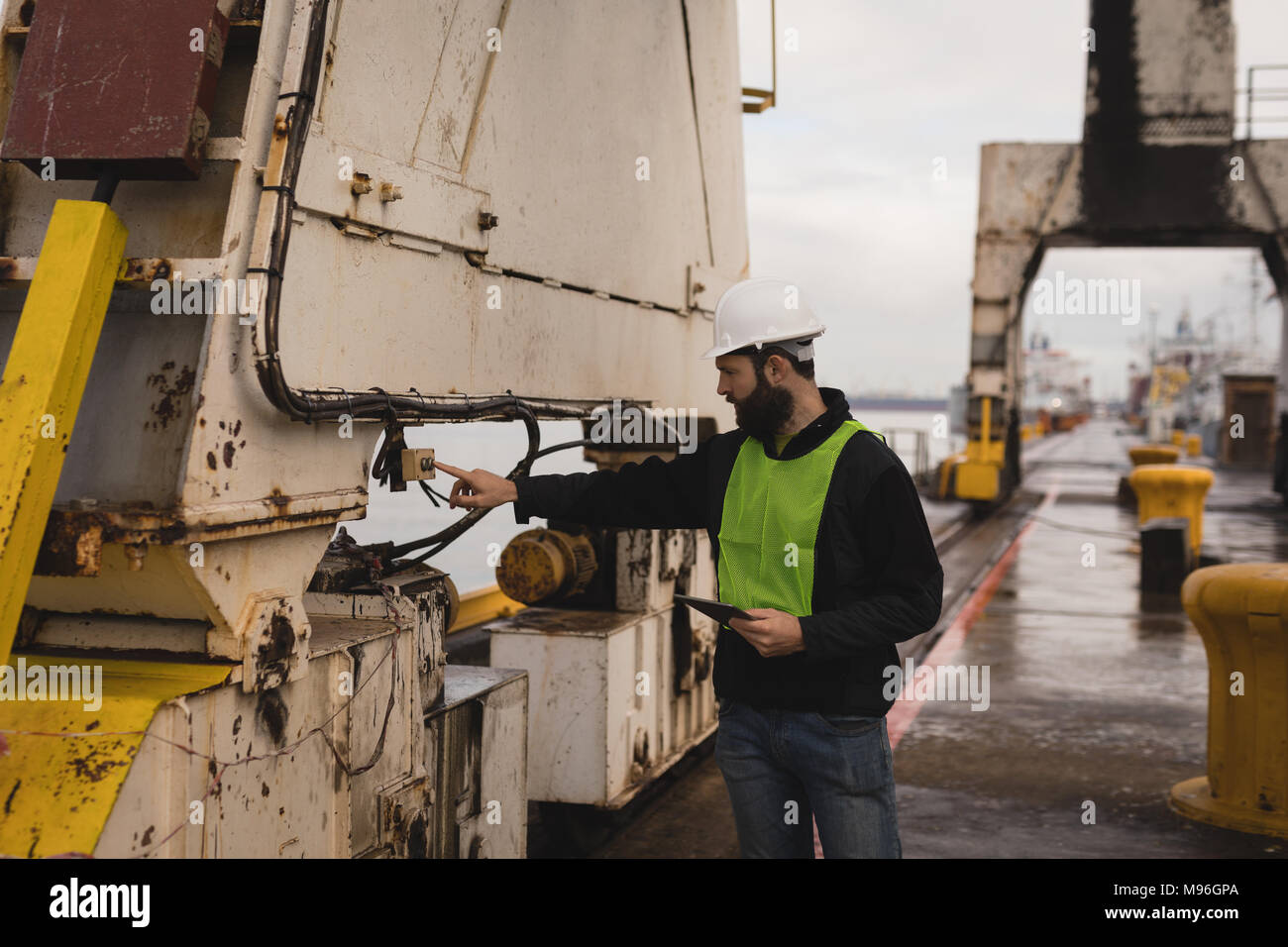 Dock worker pressing button of crane Stock Photo