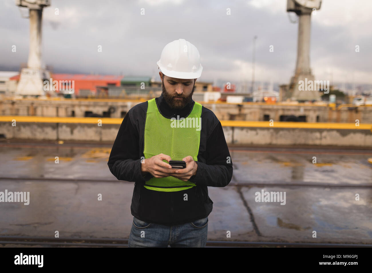 Dock worker using mobile phone Stock Photo