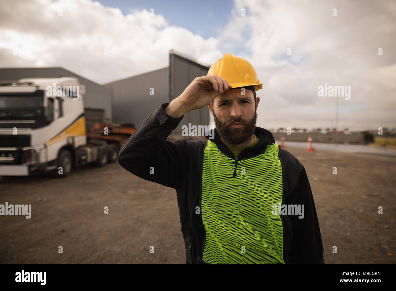 Dock worker holding his hat in shipyard Stock Photo