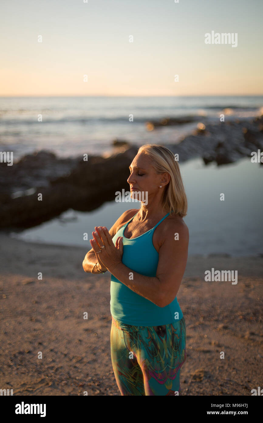 Disabled woman meditating in the beach Stock Photo