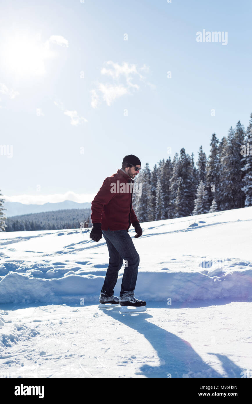 Man skating in snowy landscape Stock Photo