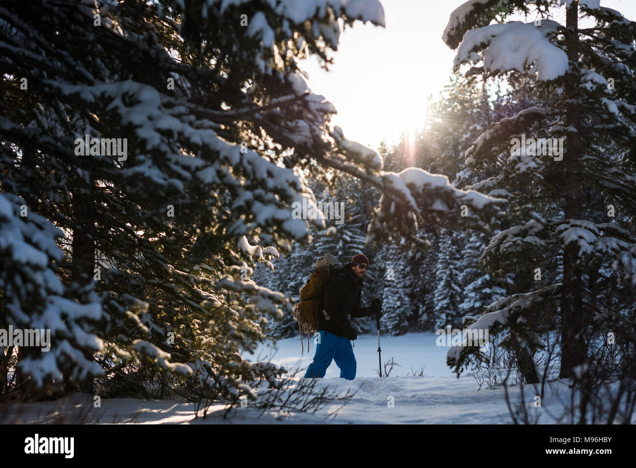 Man walking with backpack in snowy landscape Stock Photo