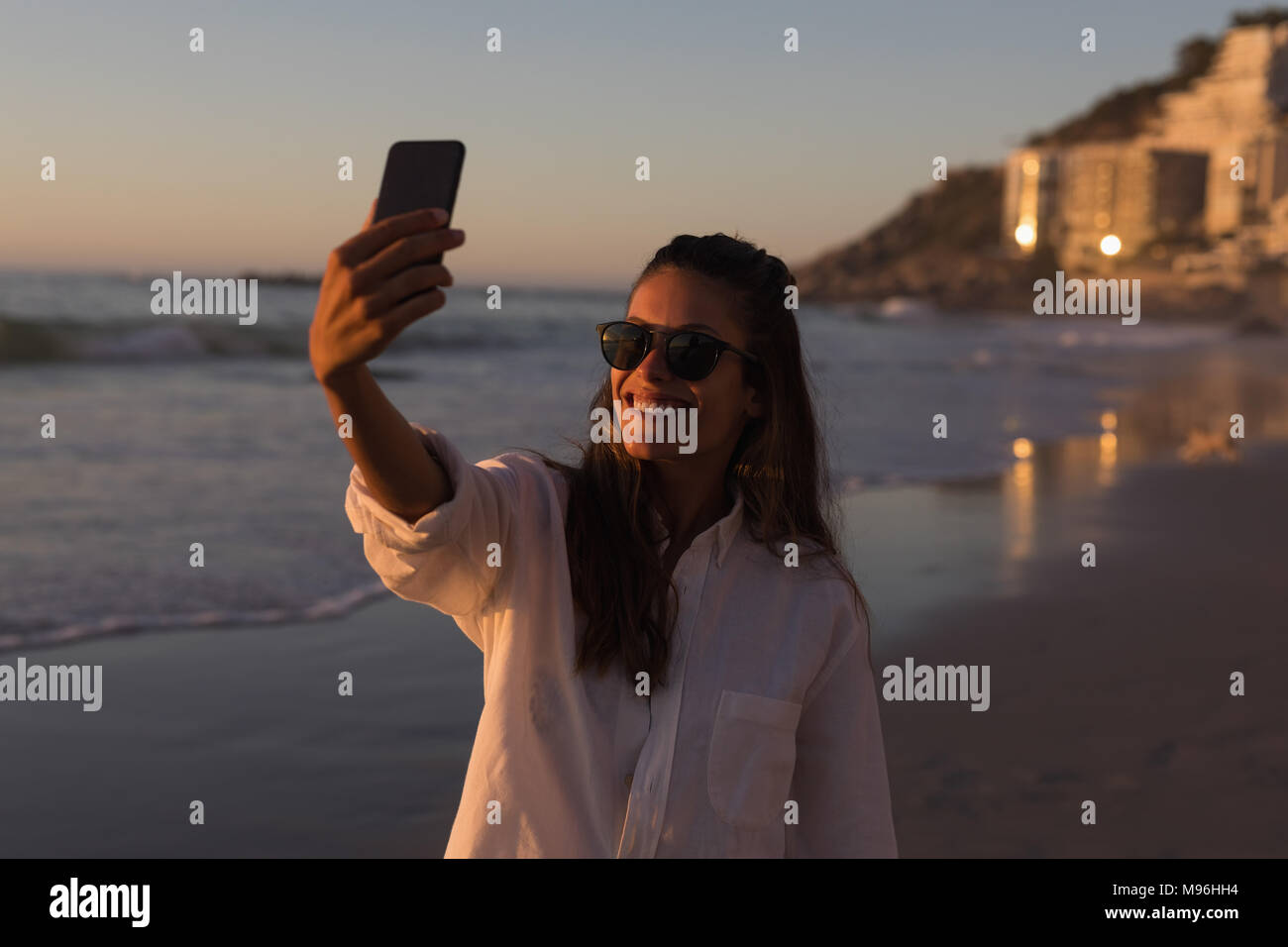 Woman taking selfie with mobile phone in the beach Stock Photo - Alamy