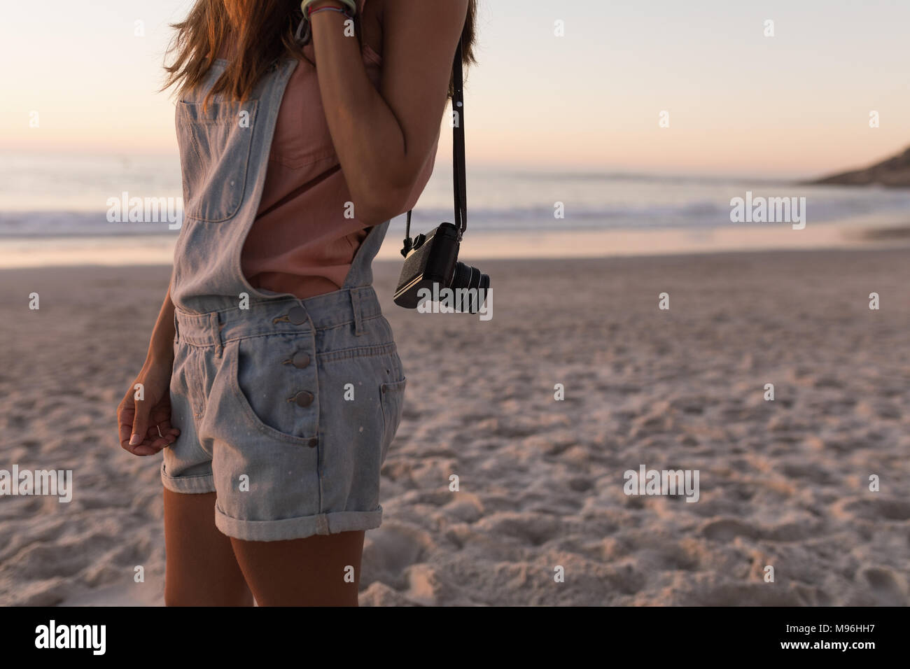 Woman holding vintage camera in the beach Stock Photo