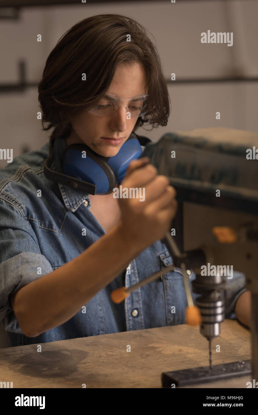 Female welder using vertical drilling machine Stock Photo