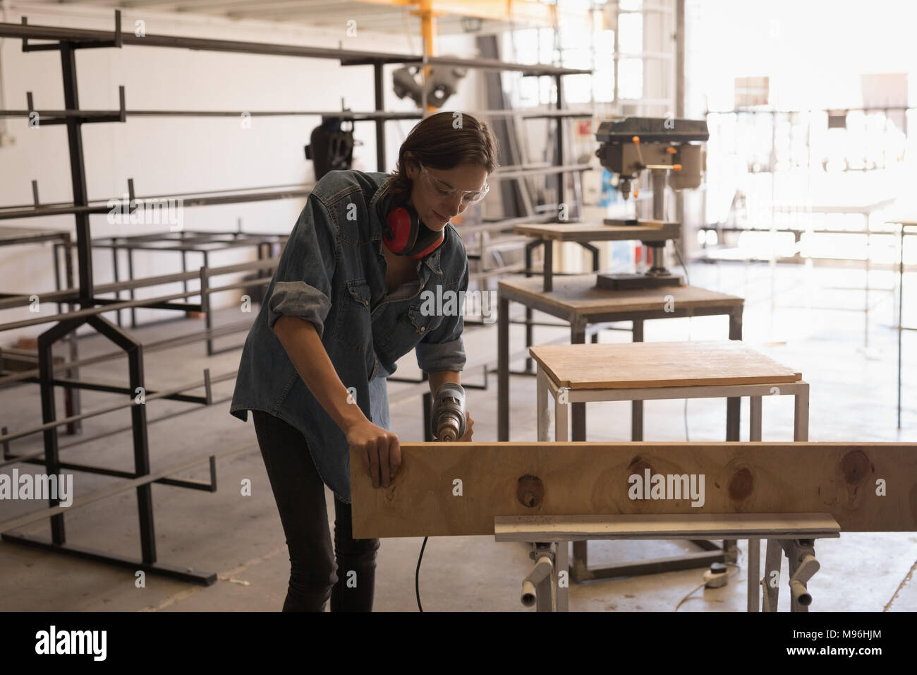 Female welder using drilling machine Stock Photo