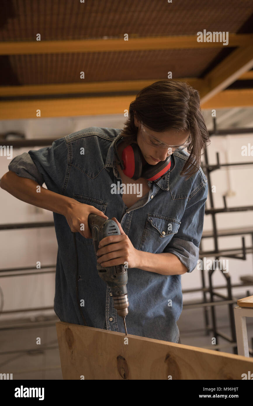 Female welder using drilling machine Stock Photo