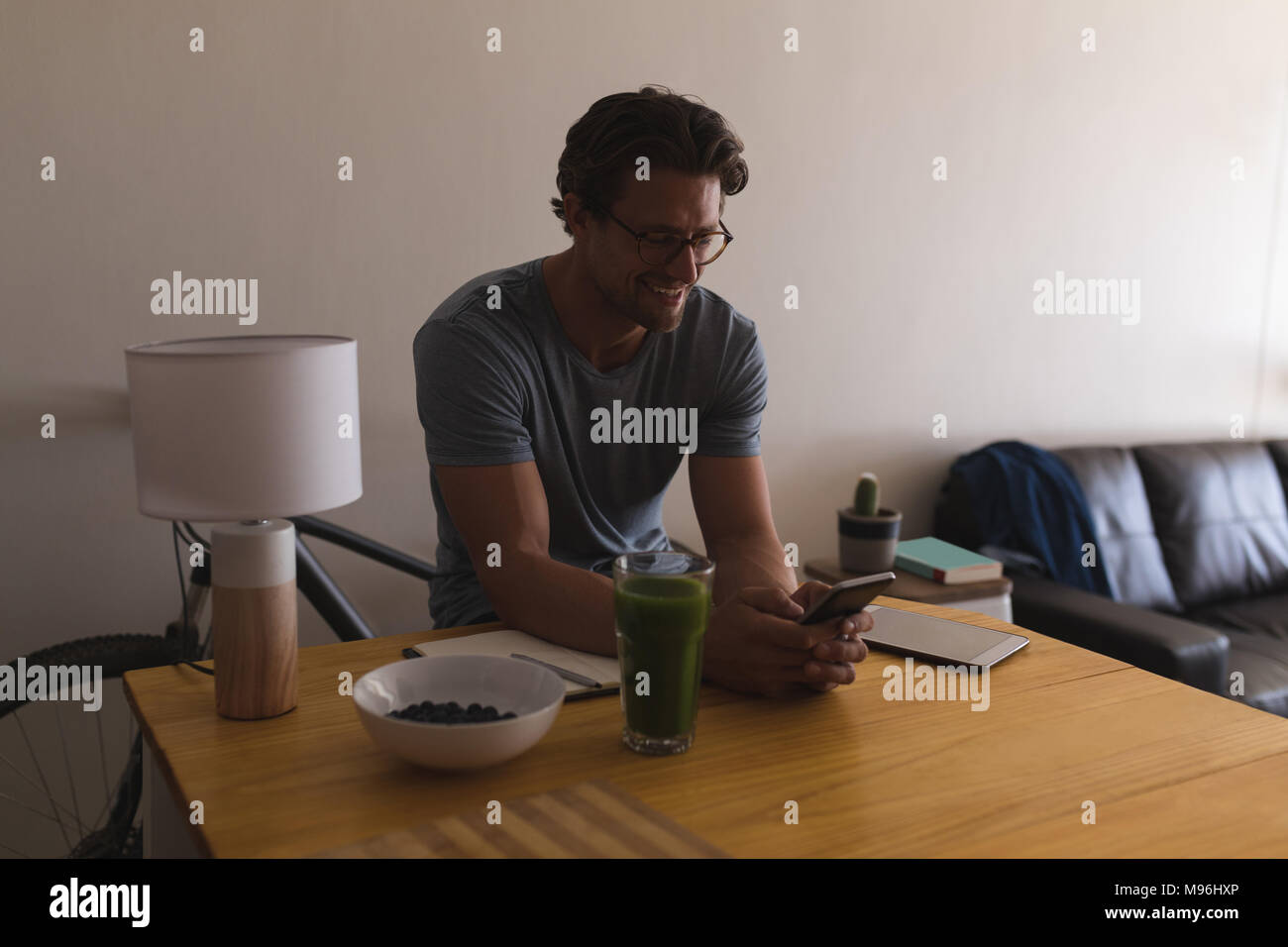 Man using mobile phone in living room Stock Photo