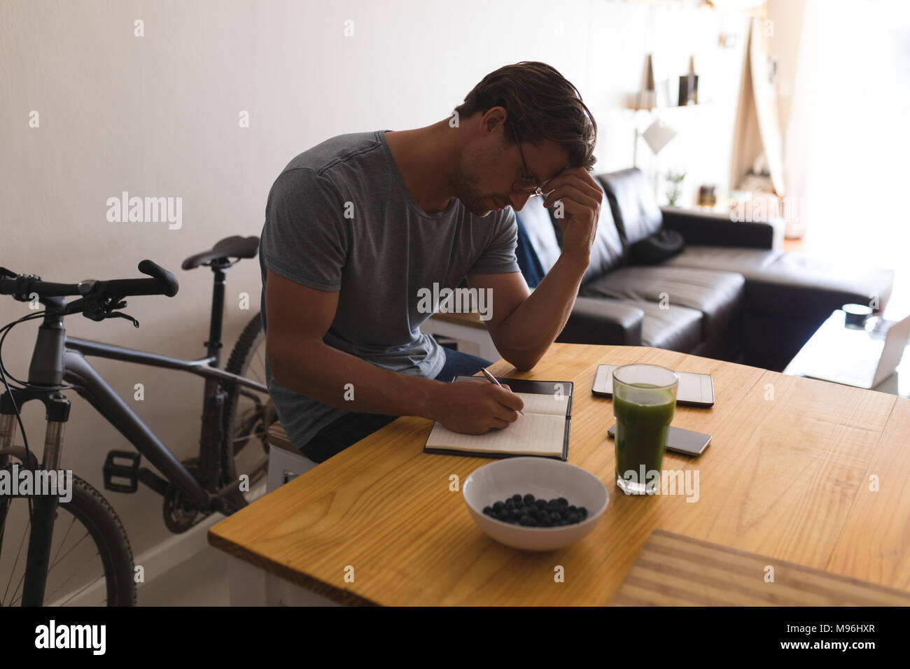 Man writing on a diary in living room Stock Photo