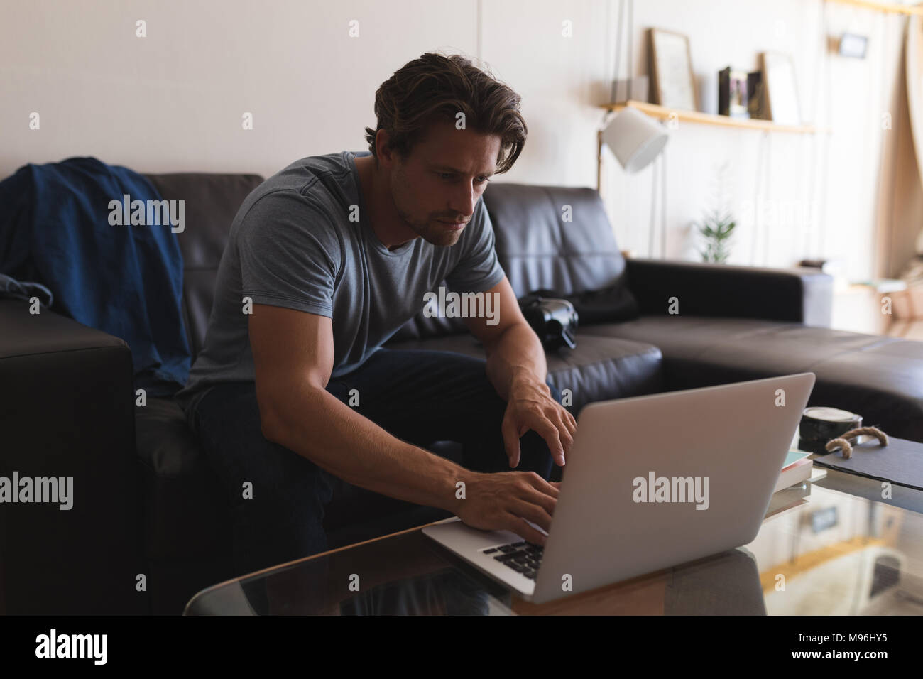 Man using laptop in living room Stock Photo