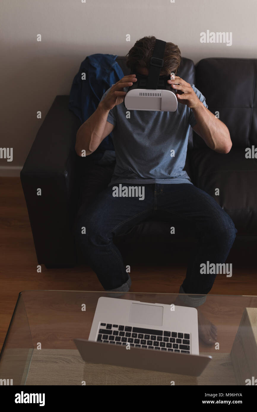 Man using virtual reality headset in living room Stock Photo
