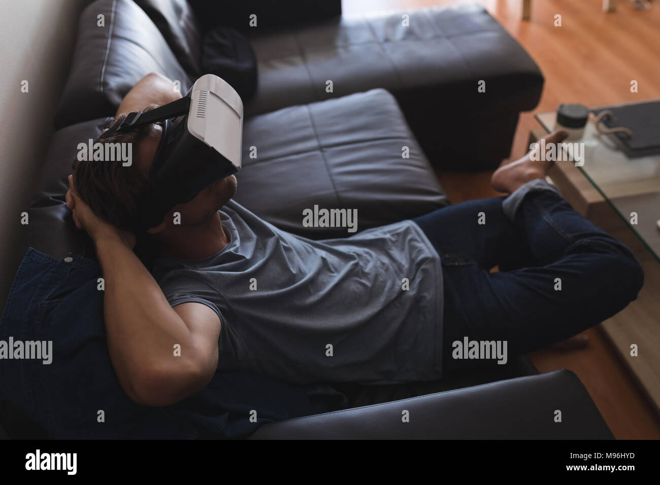 Man using virtual reality headset in living room Stock Photo