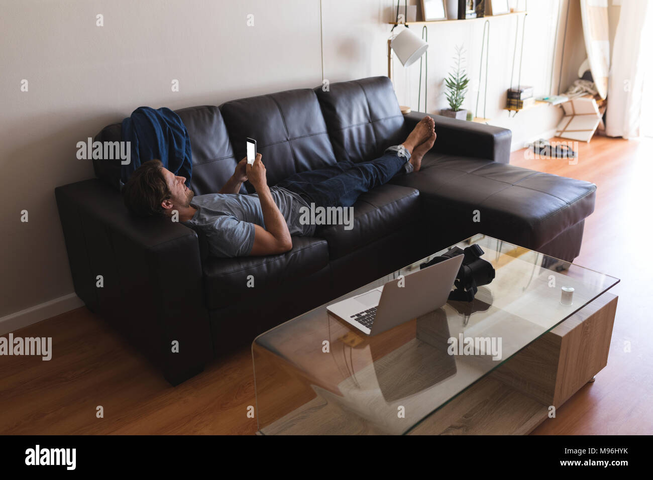 Man using mobile phone in living room Stock Photo