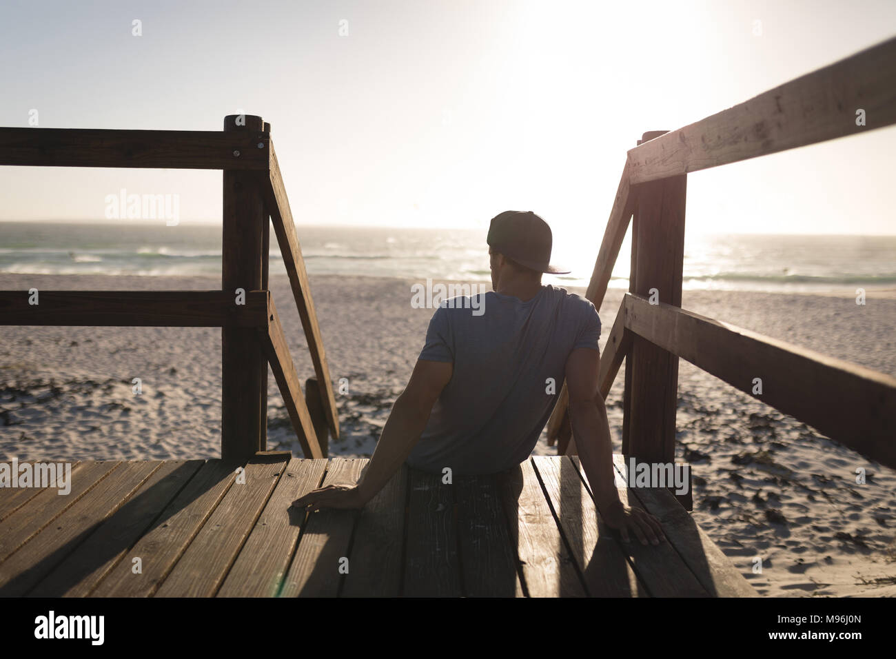Male surfer relaxing on watchtower in the beach Stock Photo