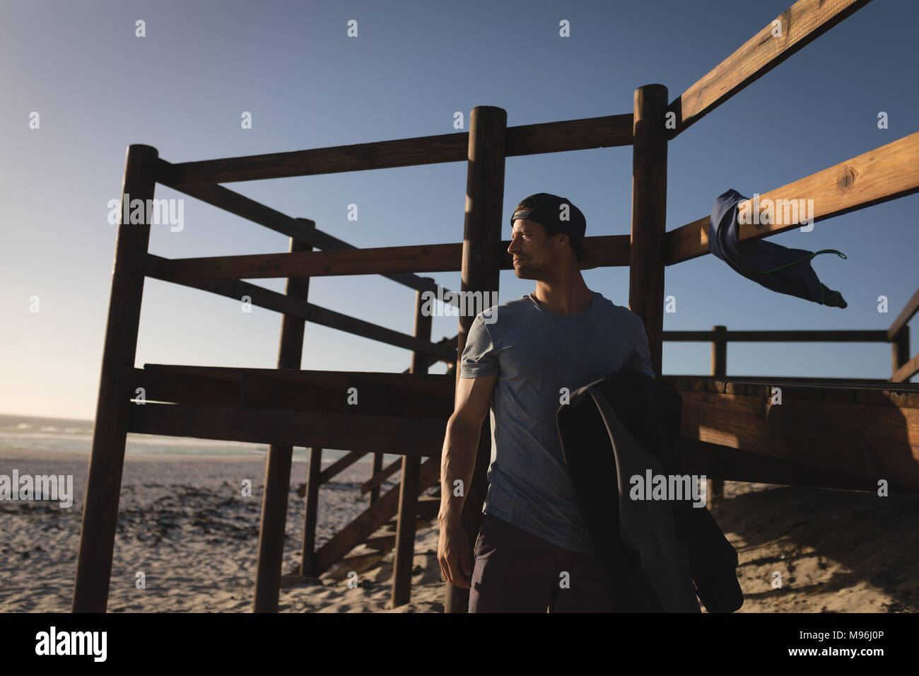 Male surfer standing on the beach Stock Photo