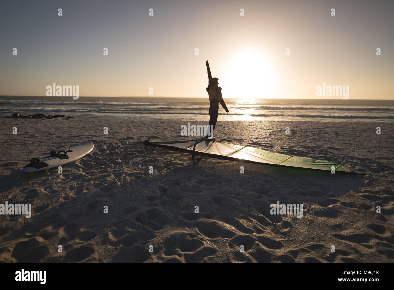 Male surfer standing with kite and surfboard on the beach Stock Photo