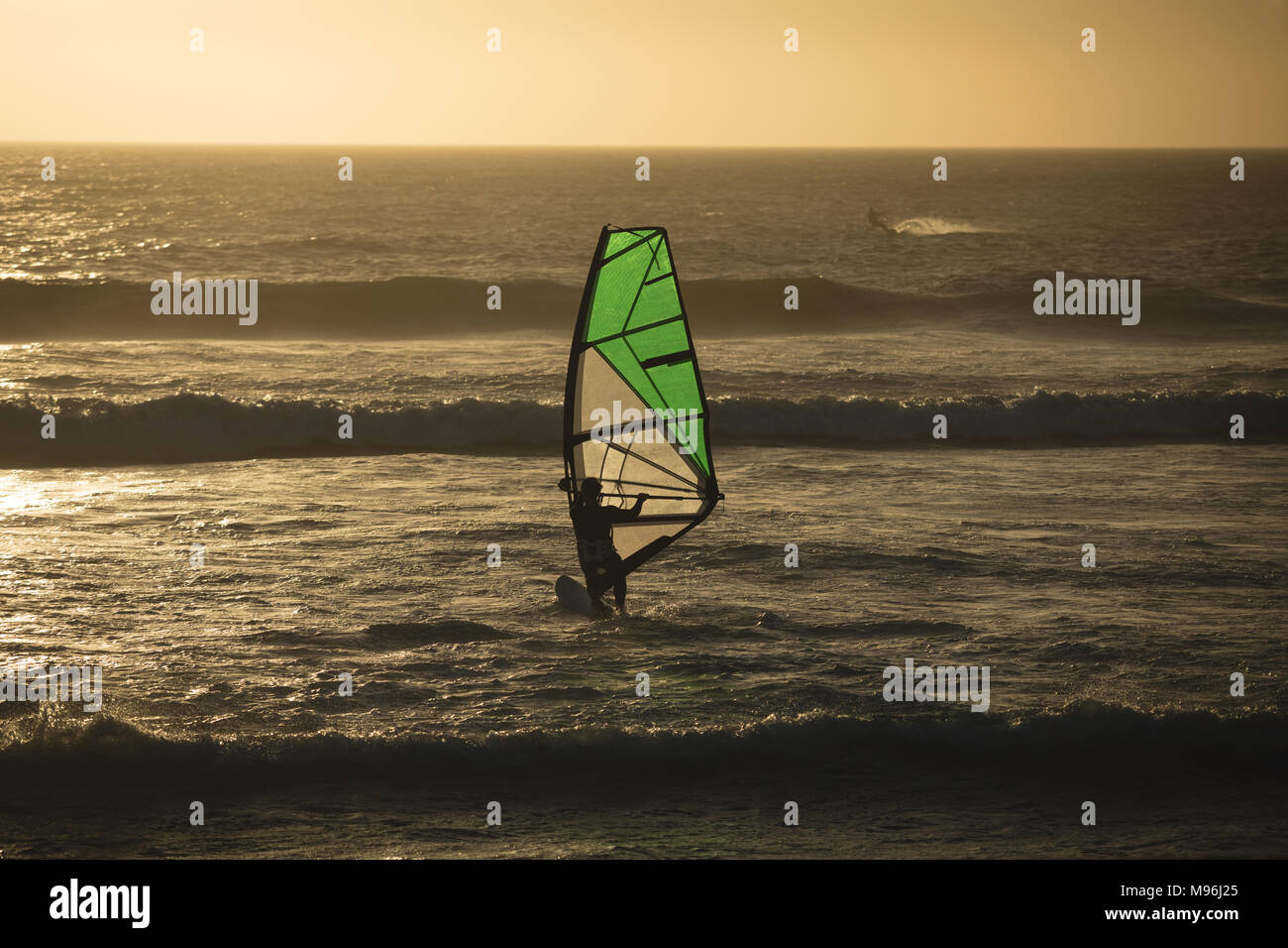 Male surfer surfing with surfboard and kite Stock Photo