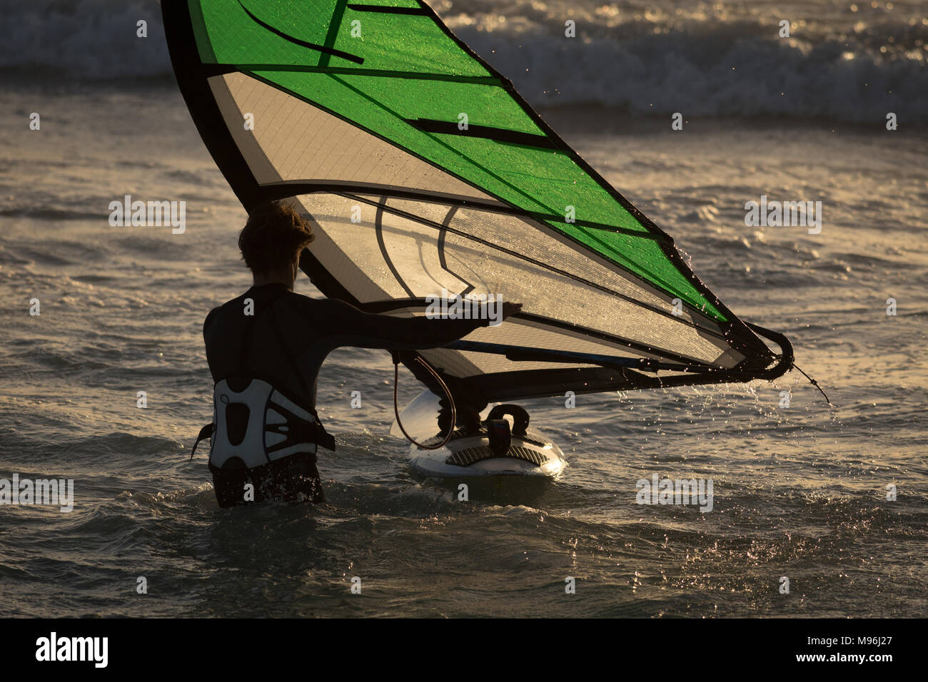 Male surfer surfing with surfboard and kite Stock Photo