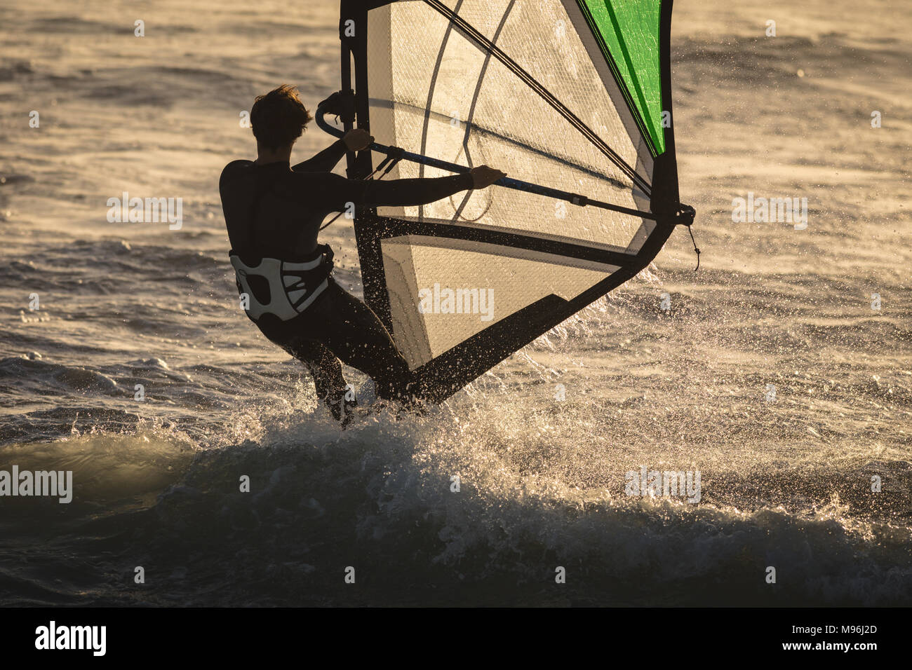 Male surfer surfing with surfboard and kite Stock Photo