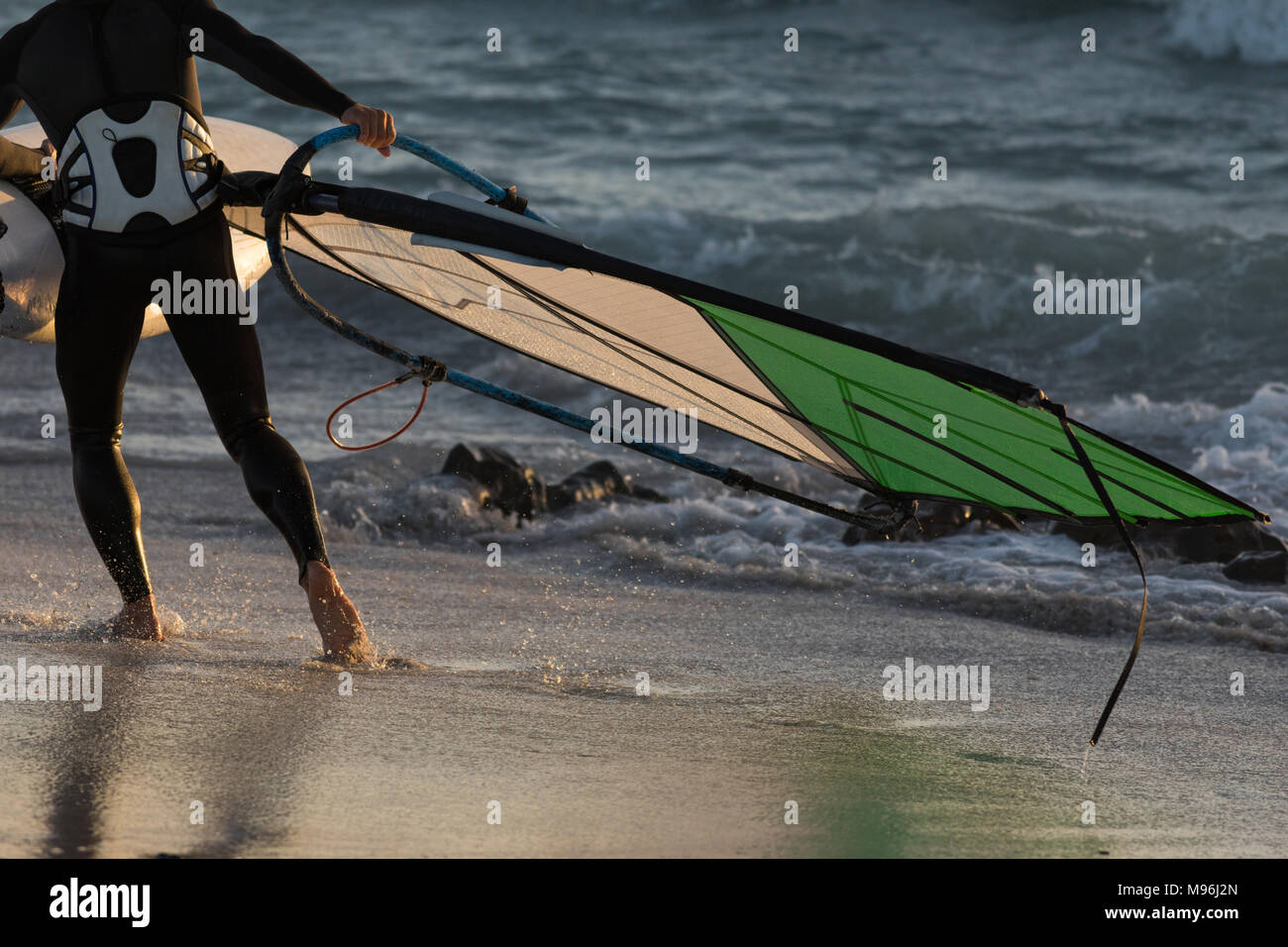 Male surfer holding a kite on the beach Stock Photo