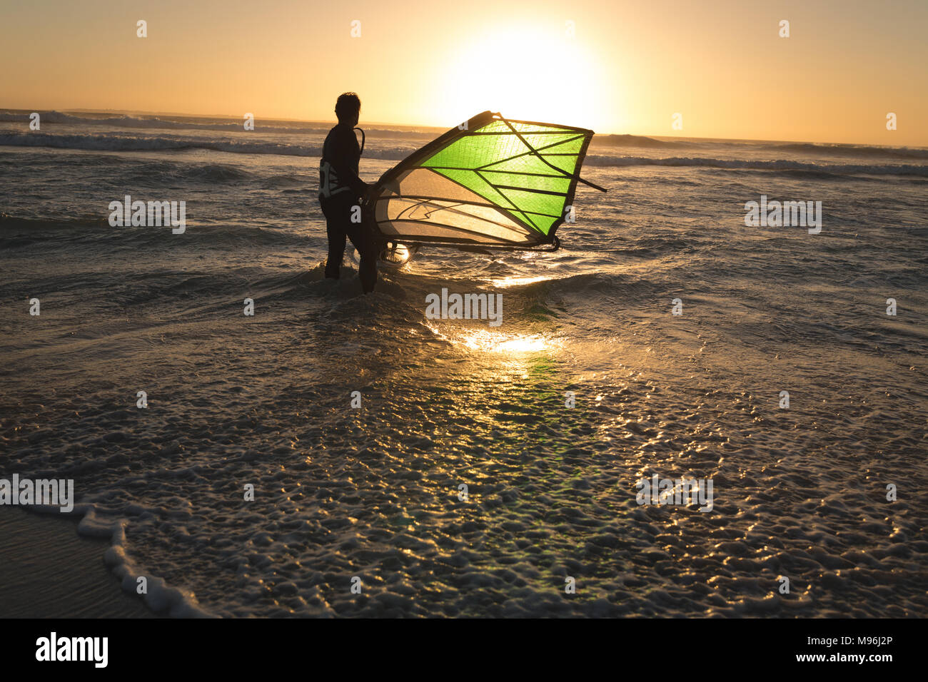 Male surfer surfing with surfboard and kite Stock Photo