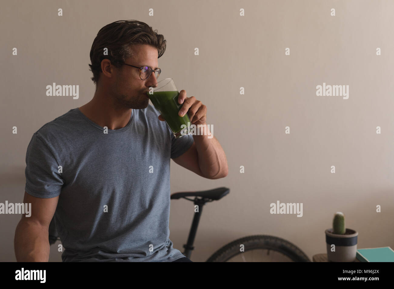 Man having a diet juice in living room Stock Photo