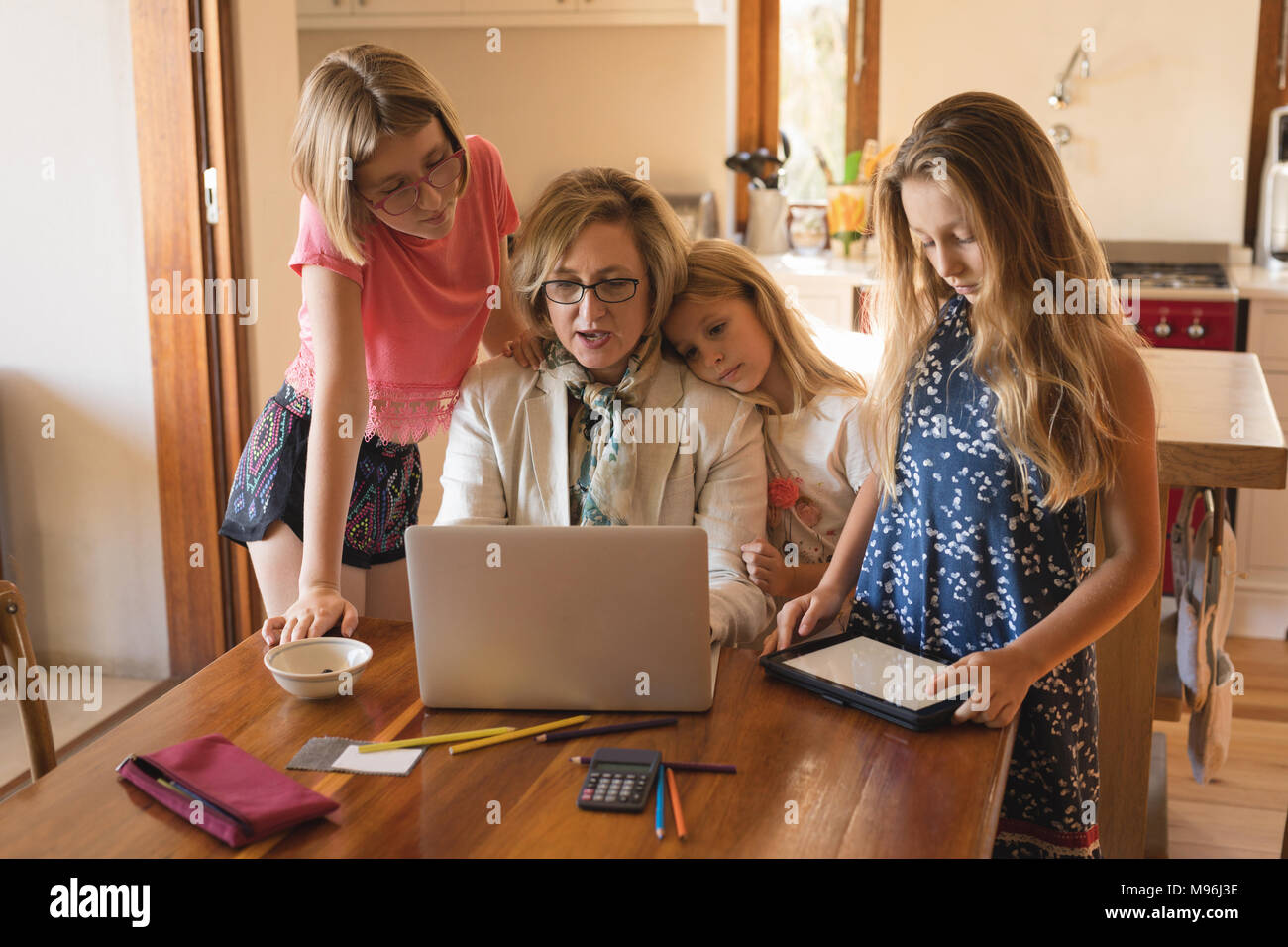 Mother and daughters using laptop and digital tablet Stock Photo