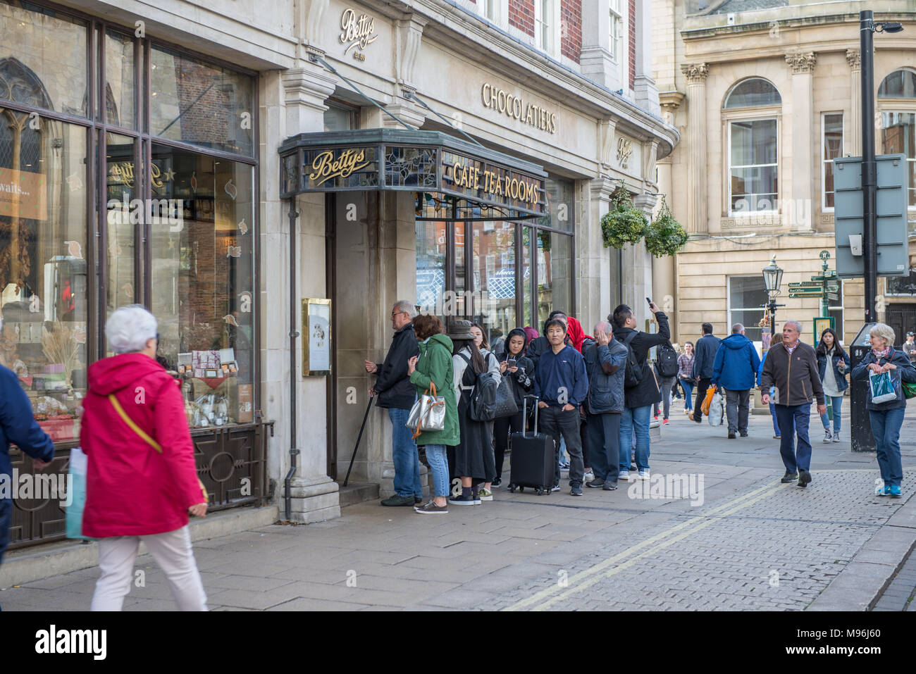 People queuing for afternoon tea outside Bettys Cafe and Tea Room St Helen's Square York UK Stock Photo