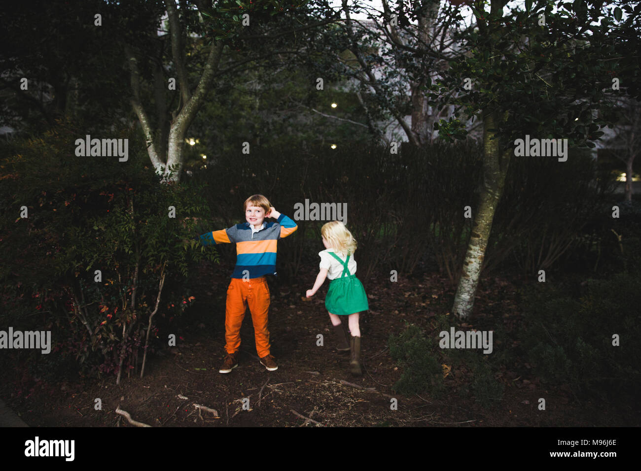 Two children playing in the woods Stock Photo