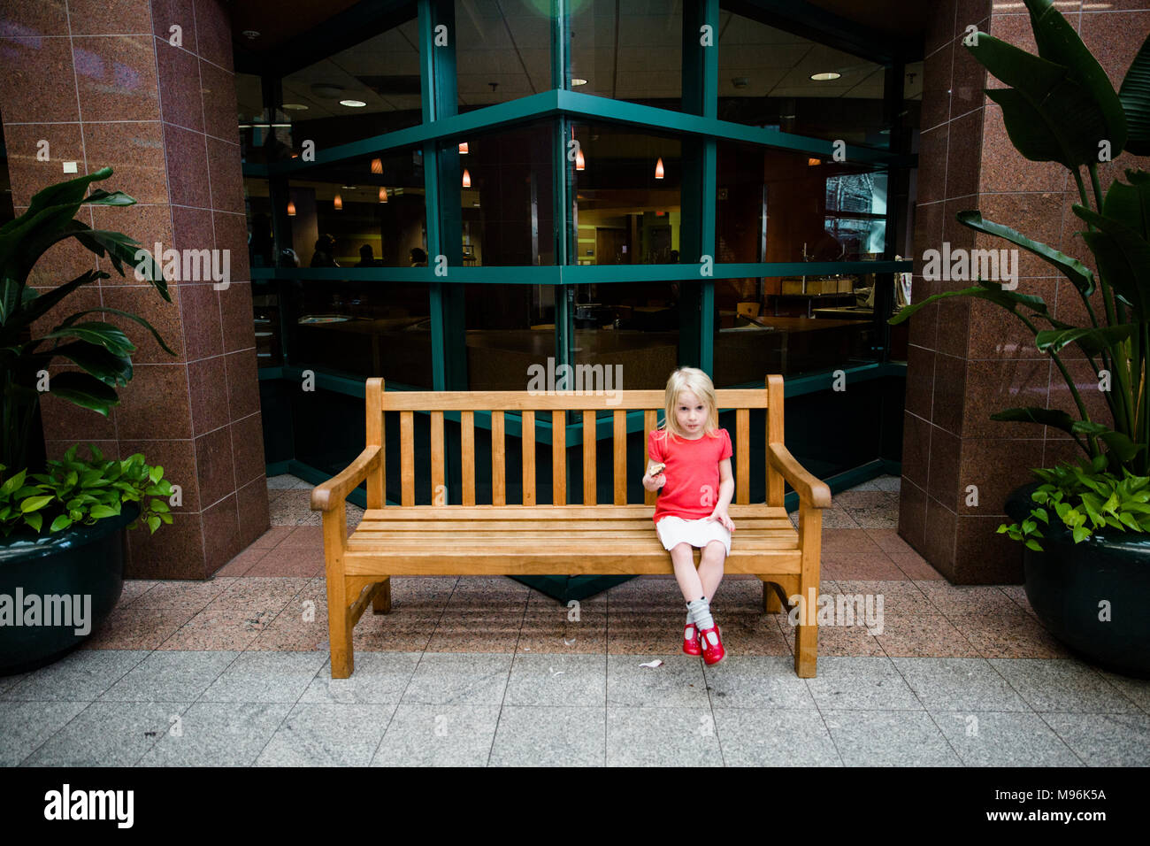 Girl sitting alone on bench hi-res stock photography and images - Alamy