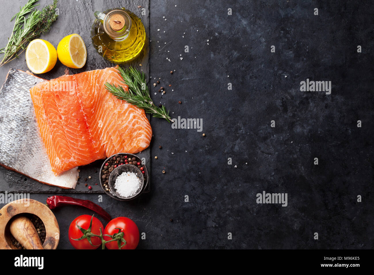 Raw salmon fish fillet with spices cooking on cutting board. Top view ...