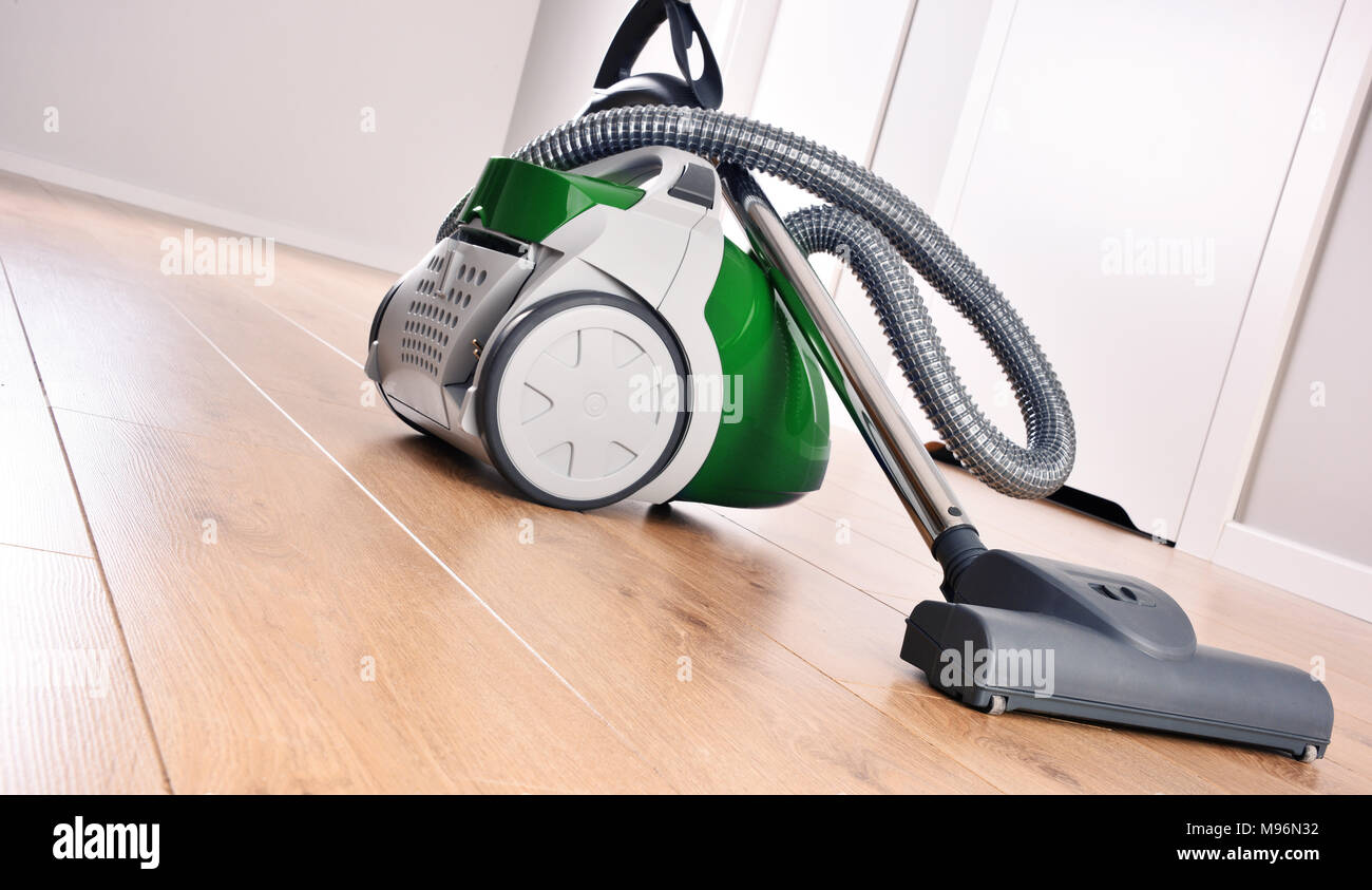 Canister vacuum cleaner for home use on the floor panels in the apartment. Stock Photo
