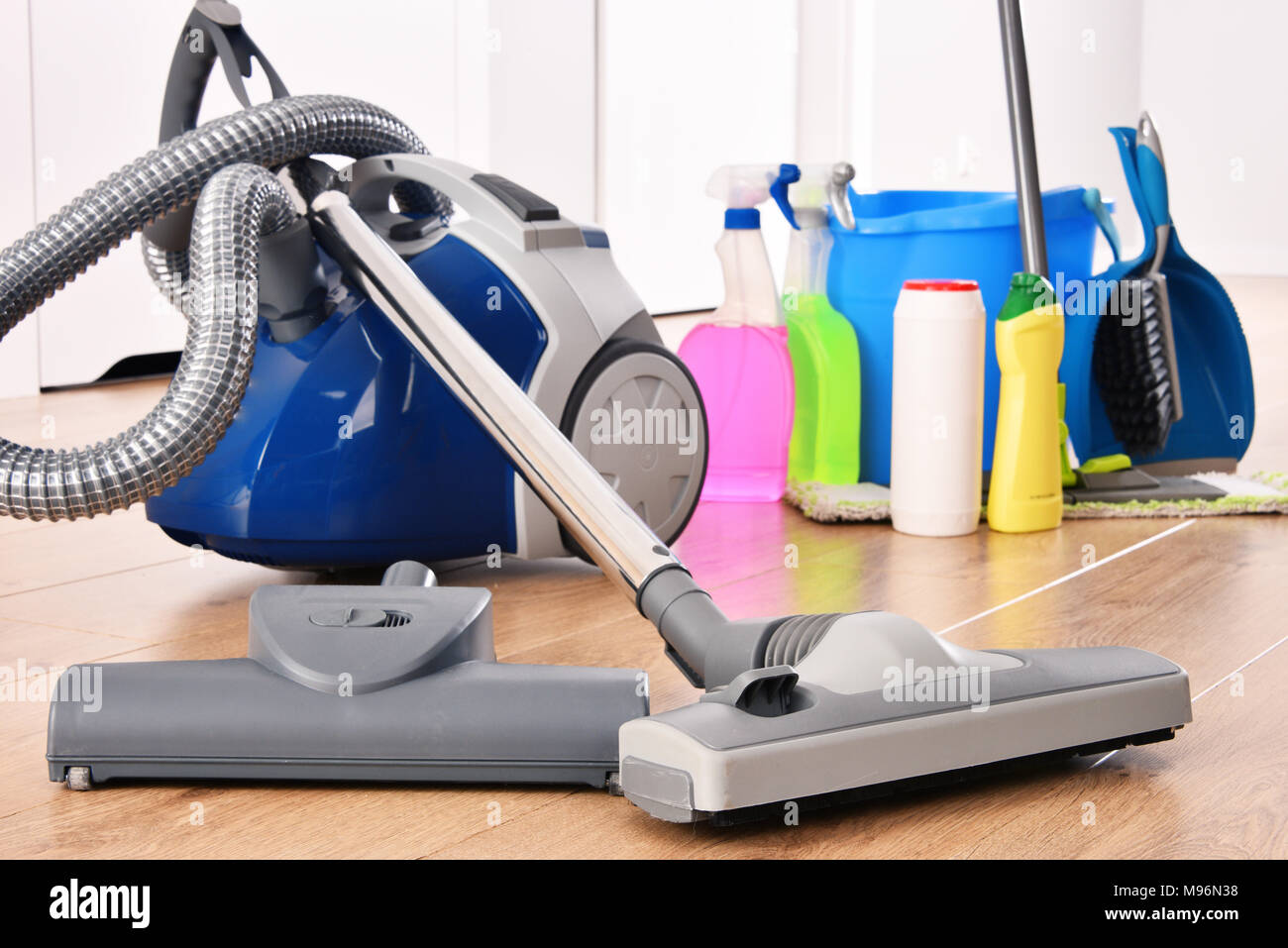 Vacuum cleaner and variety of detergent bottles and chemical cleaning supplies on the floor
