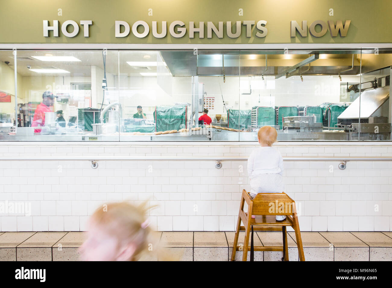 Children looking at doughnuts being prepared Stock Photo