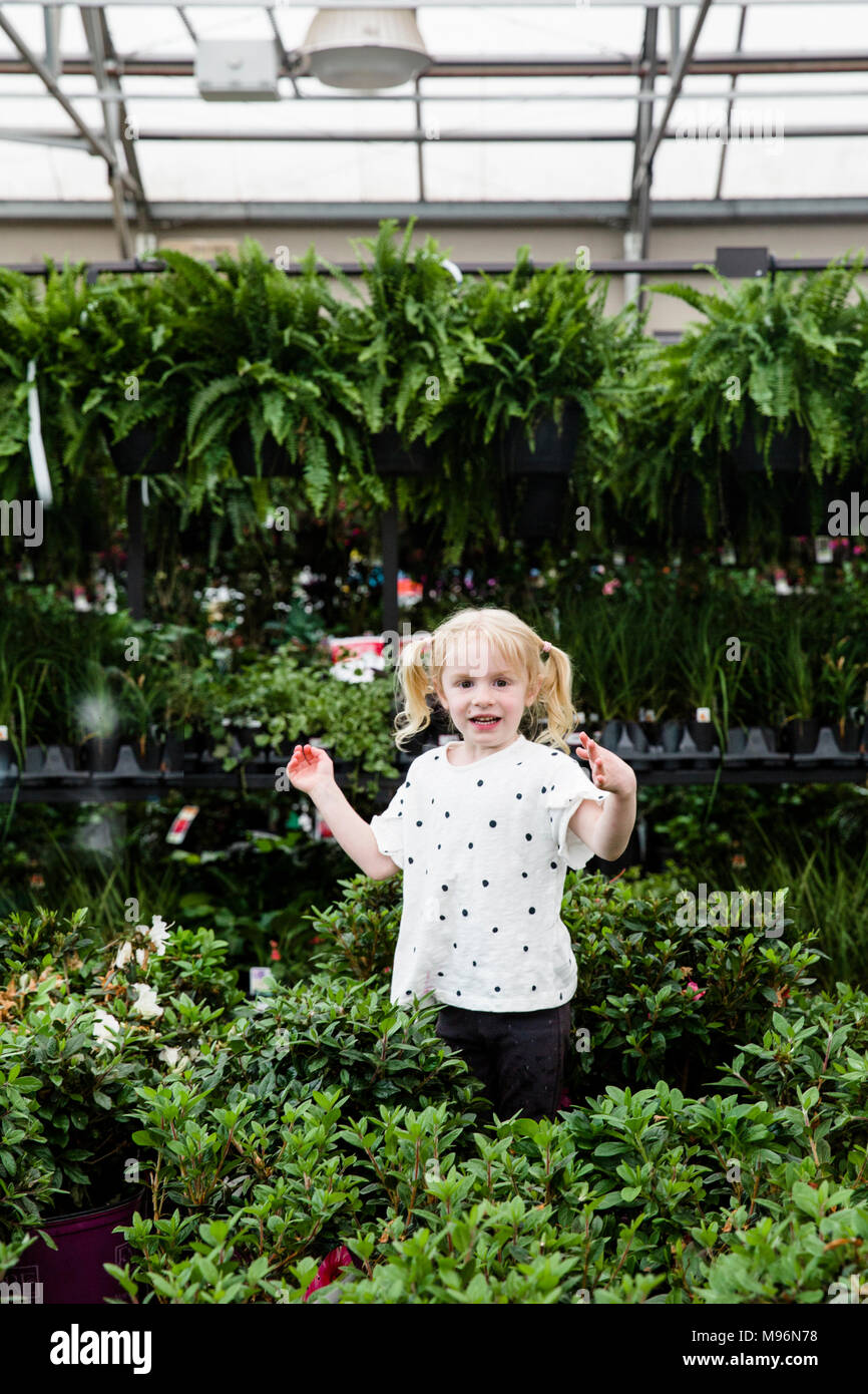 Girl in and around greenhouse within Garden Center Stock Photo - Alamy