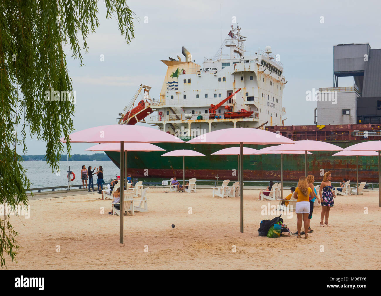 Urban beach next to Lake Ontario with bulk cargo carrier Mandarin in the background, Toronto, Ontario, Canada Stock Photo