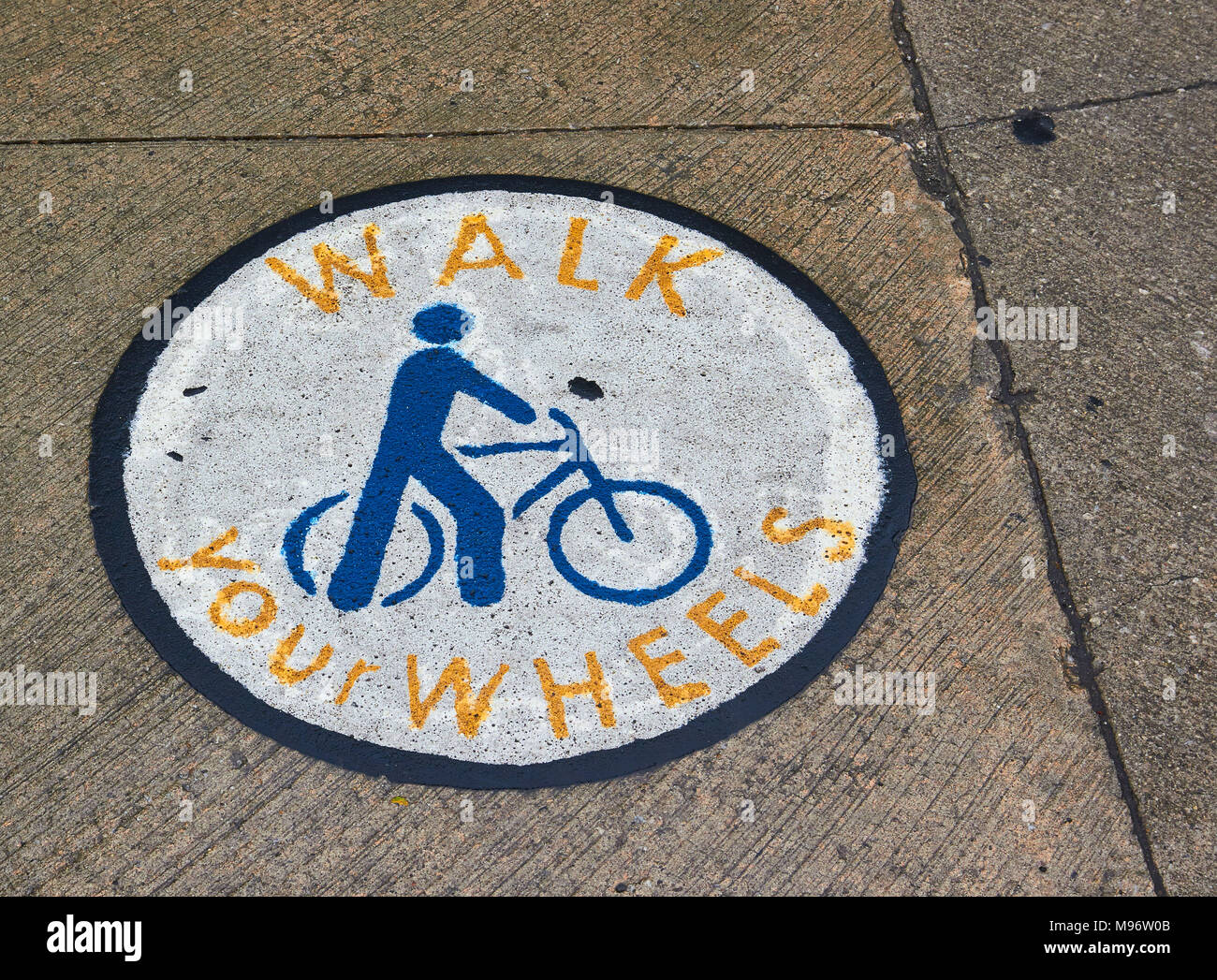 Sign on pavement asking cyclists to walk with their bikes, Toronto, Ontario, Canada Stock Photo