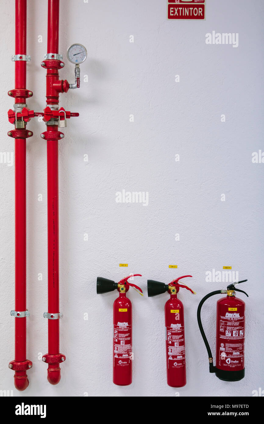 Fire extinguishers hanging from a wall Stock Photo