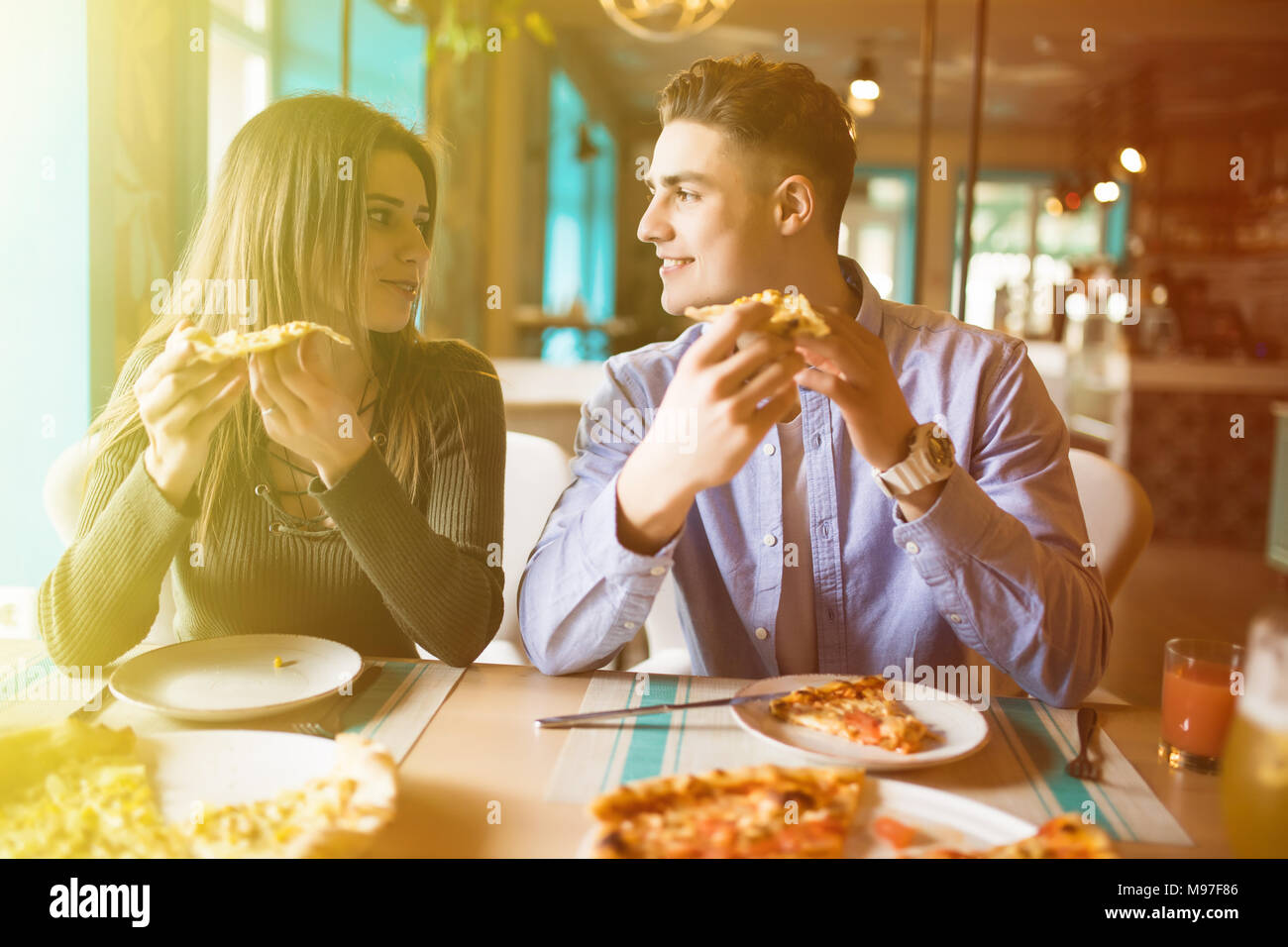 Close up photo of young couple enjoying in pizza, having fun together. Consumerism, food, lifestyle concept Stock Photo