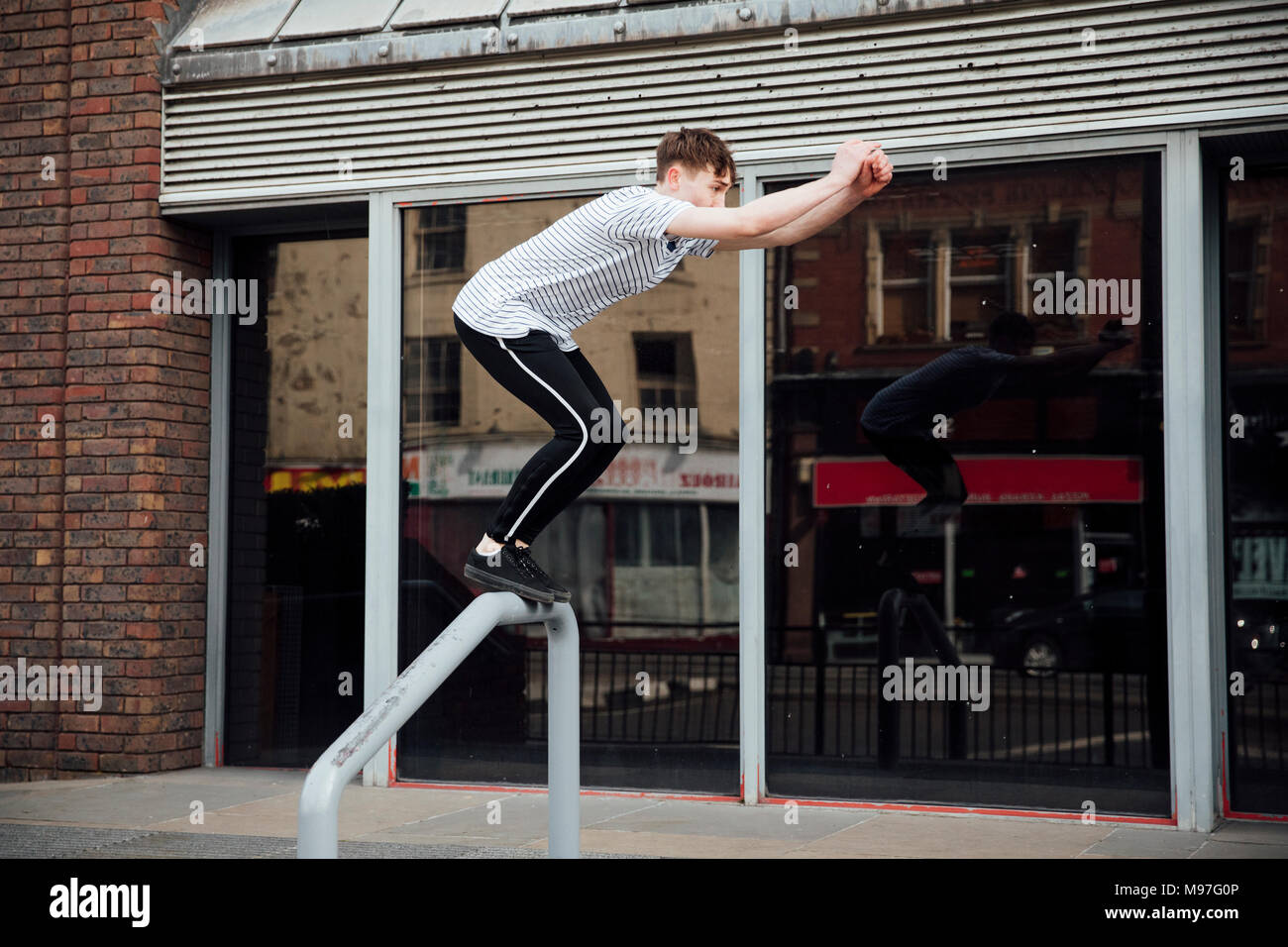 Freerunner is jumping between walls and railings in the city Stock