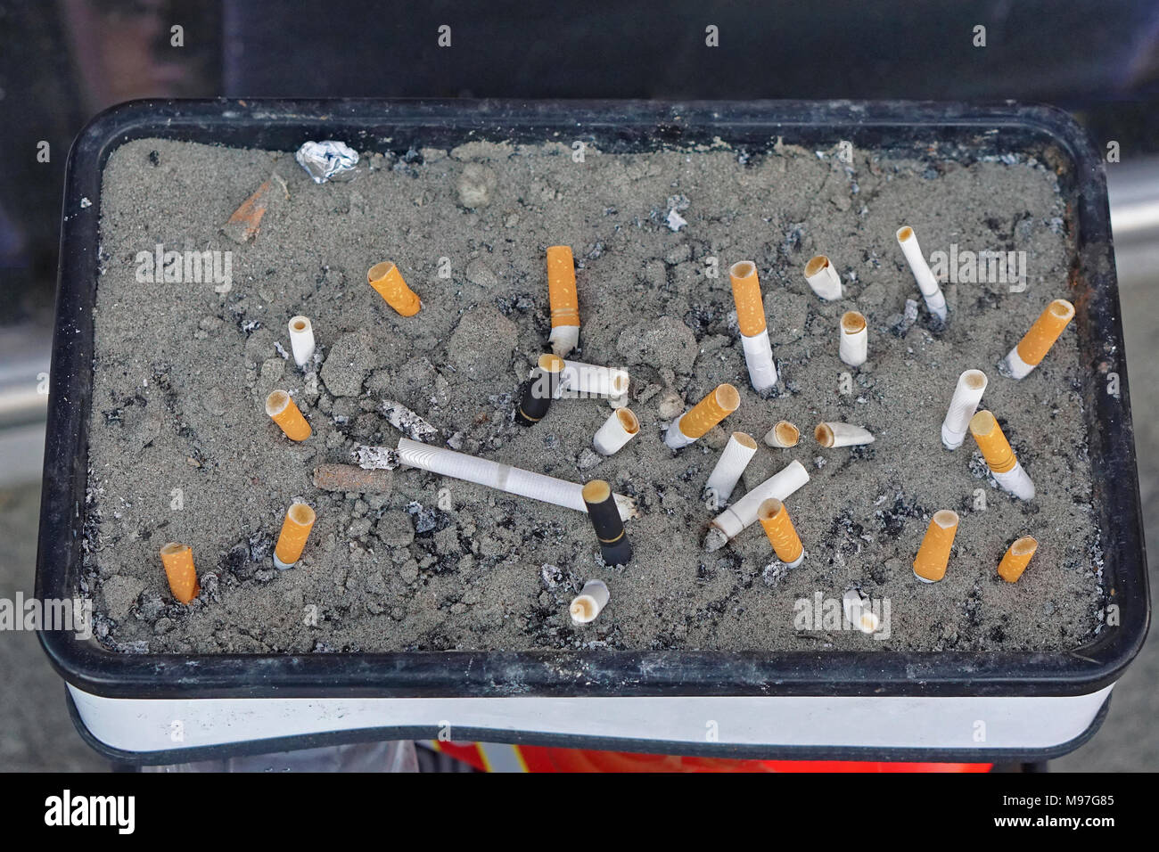 Ashtray with cigarette buts in sand Stock Photo Alamy