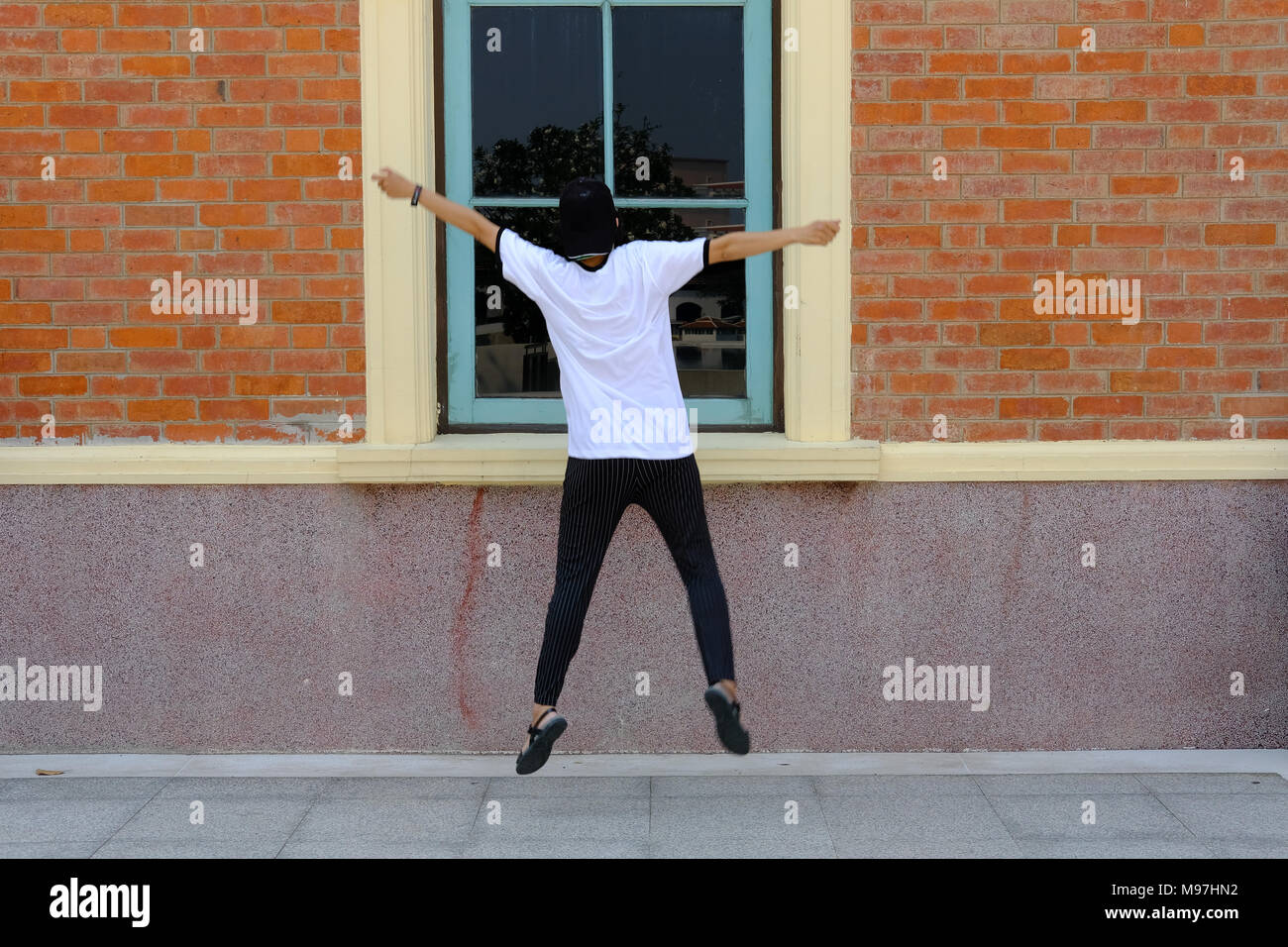 backside of woman jumping with happiness outdoors. Stock Photo