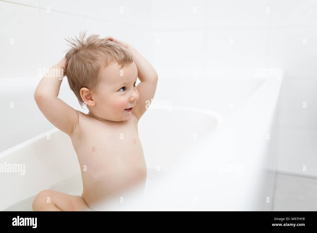 Adorable young toddler in the bathroom having a bath Stock Photo Alamy