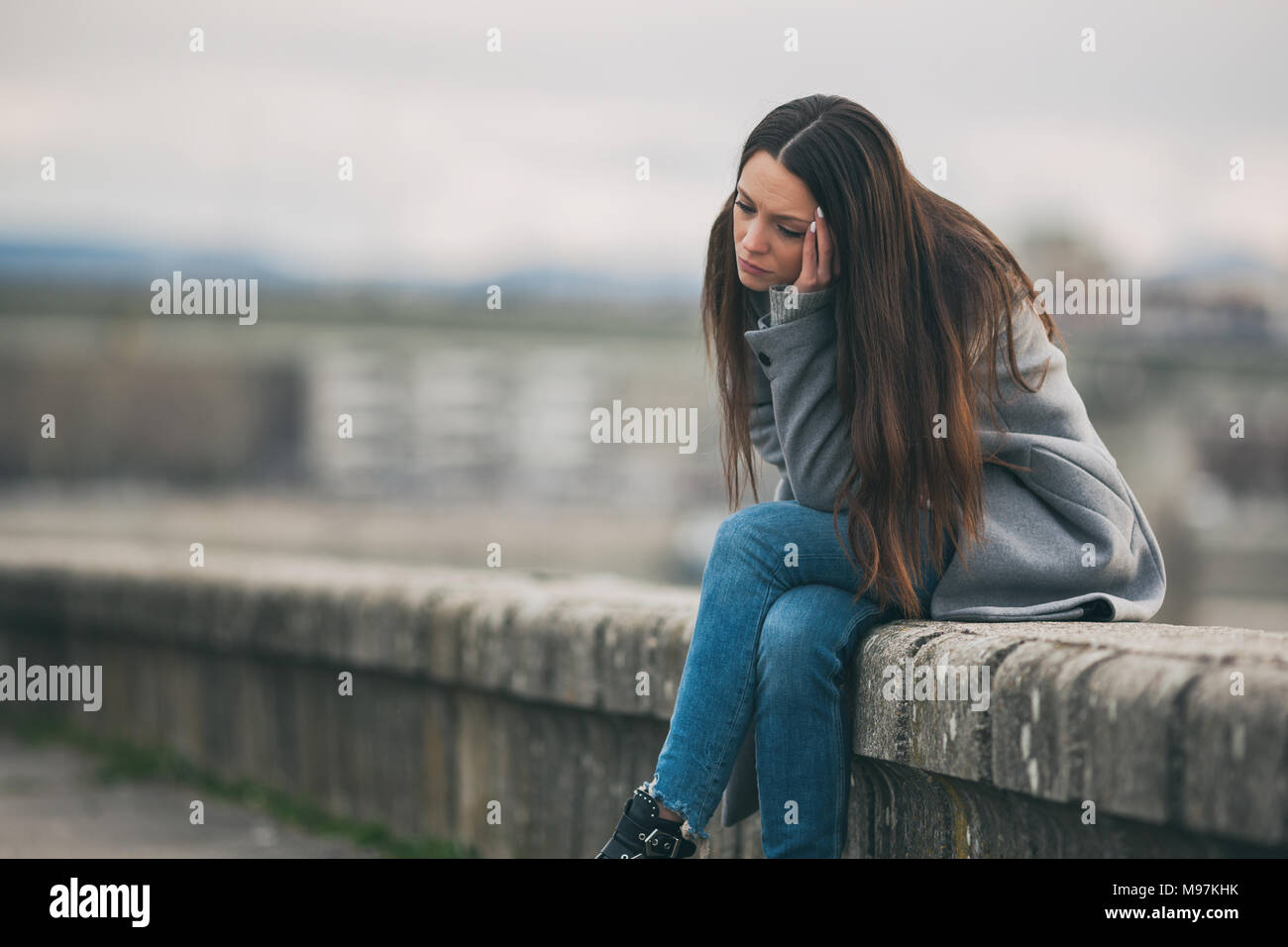 Young lonely and depressed woman is sitting in grief. Stock Photo