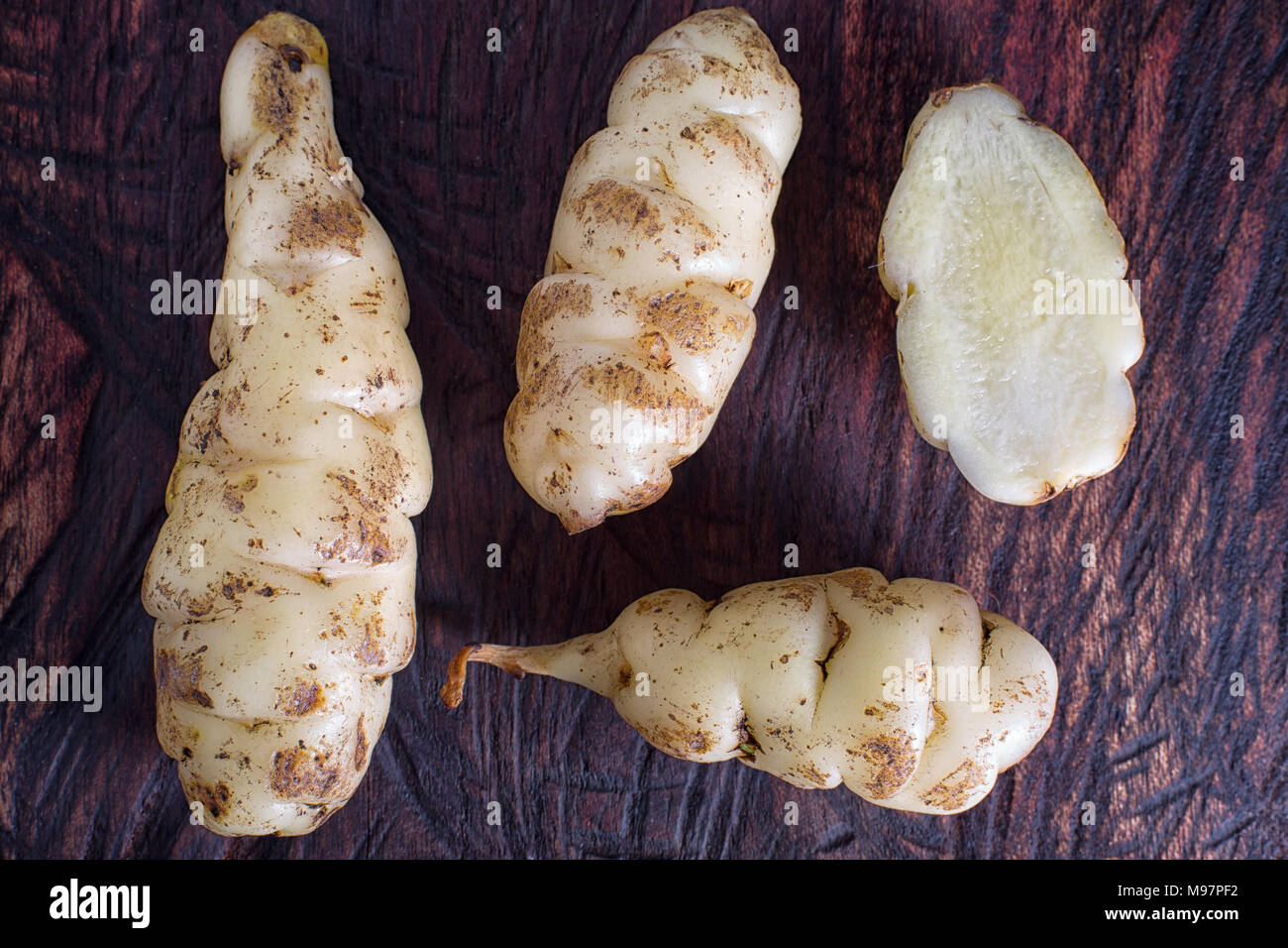 Oxalis tuberosa also known as oca tuber on rustic background Stock