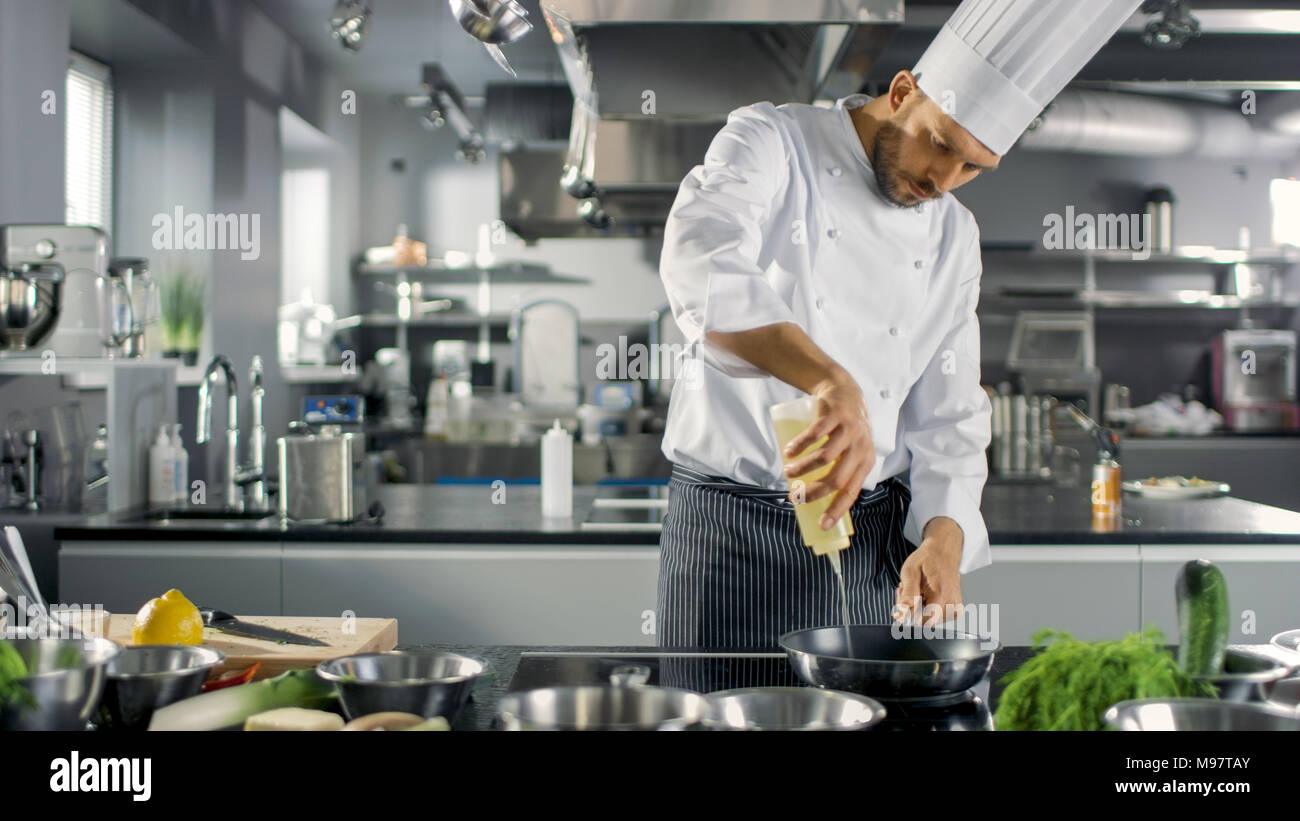 Professional Chef Working in a Famous Restaurant Kitchen. Starts Preparing His Specialized Dish, Turns on Stove and Puts Pan with Oil on it. Stock Photo