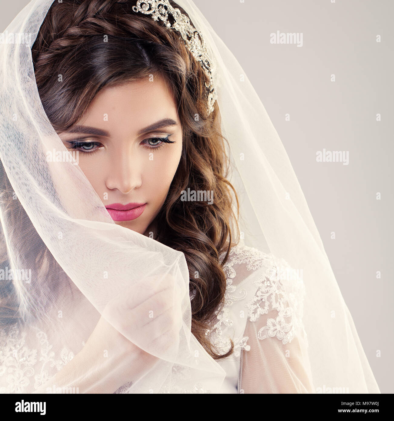Fashion Portrait of Perfect Bride. Beautiful Fiancee with Curly Hair, Makeup and White Veil Stock Photo