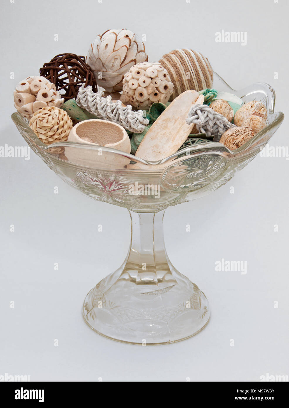 Clear glass vase filled with decorative material against a light background Stock Photo