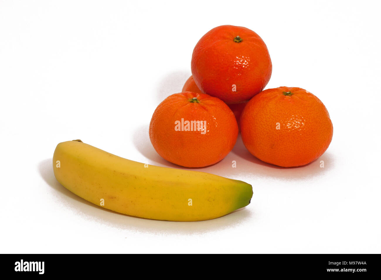 Stacked Oranges And A Banana With White Background Isolated Stock Photo